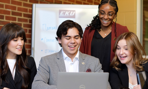 A group of EKU students sitting in the business building around a computer