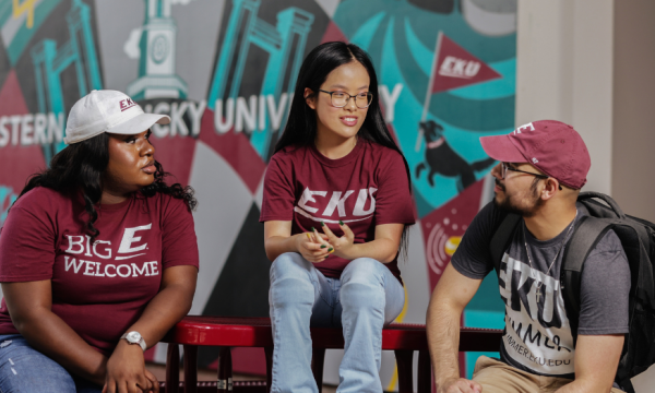 Students sitting in front of an Eastern Kentucky University mural