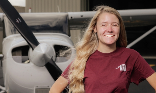 Lily Norman stands in front of aircraft at Central Kentucky Regional Airport.