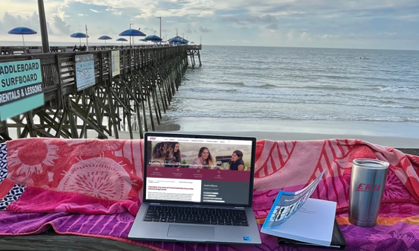 EKU Alumna, Jody Denny's laptop set up in a remote workspace on a dock facing th