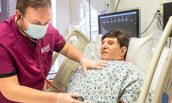 EKU nursing student practices with mannequin in hospital setting