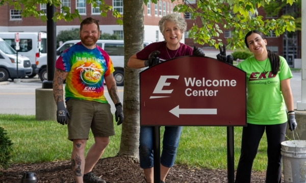 Faculty stand in front of EKU sign after day of service on campus beautiful.