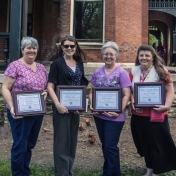 four EKU employees holding plaques