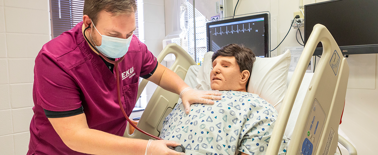 EKU nursing student practices with mannequin in hospital setting