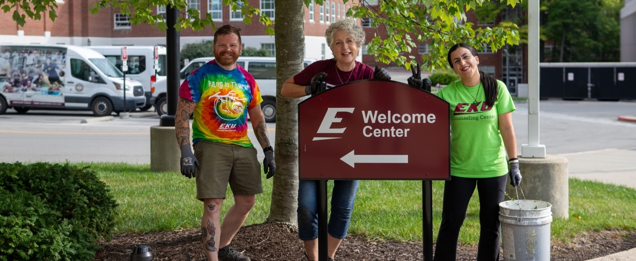 Faculty stand in front of EKU sign after day of service on campus beautiful.