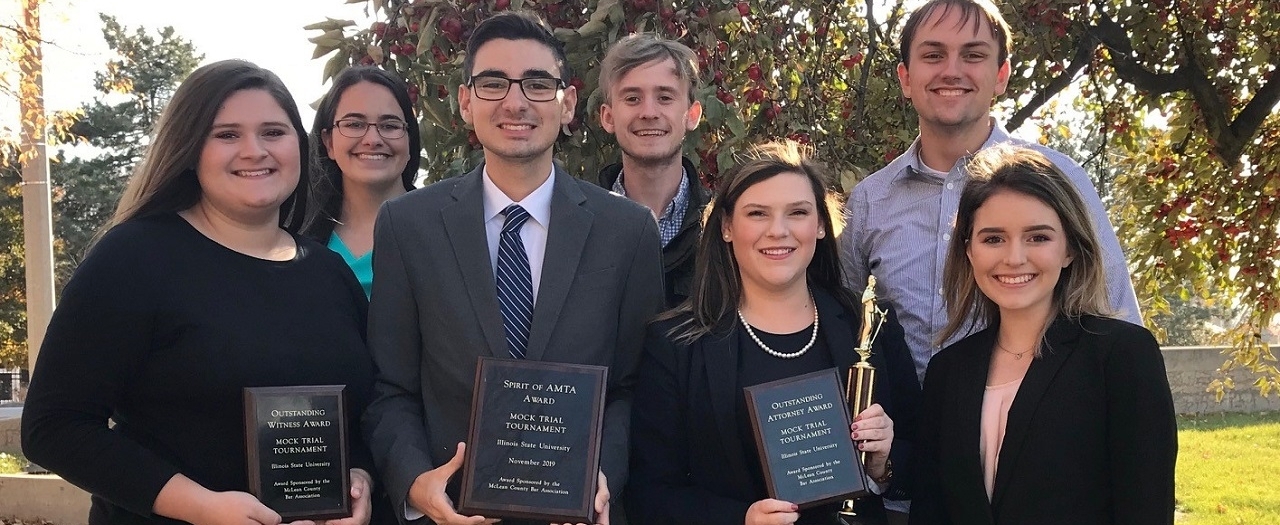 EKU's Mock Trial team holding award plaques and a trophy.